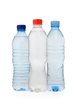 Group of three plastic water bottles with red, dark blue, and light blue ca.. 스톡 사진