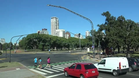 A group of three runners cross a traffic light intersection in Buenos Aires Stock Footage 143374544