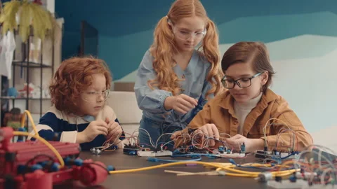 Group of Three Schoolchildren Constructing Robots in Classroom Video stock 153464530