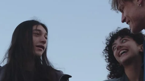 Group of Three Young Friends Sharing a Cheerful Reunion, Engaging in Stock Footage 267079082
