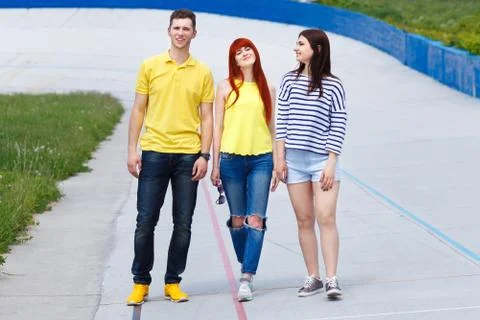 Group of  three young friends walking in the city. Stock Photos