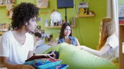 Group of three young people sitting on the couch talking Stock Footage 54938130