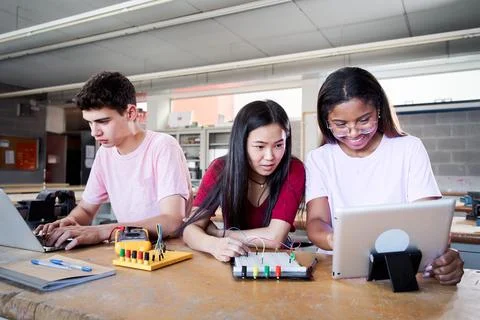Group of three young students from a technical high school doing a technological Stock Photos
