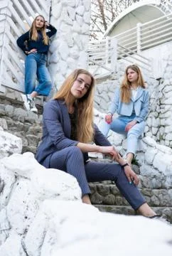 Group of three young Stylish nice girls in pantsuit costumes sitting on a stairs Stock Photos