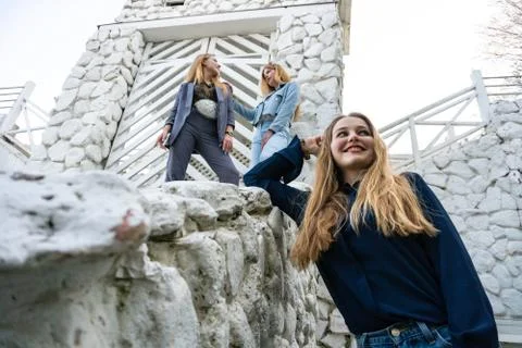Group of three young Stylish nice girls in pantsuit costumes sitting on a stairs Stock Photos