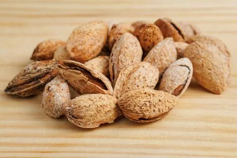 Group of toasted almonds with shell on kitchen board Stockfoto's