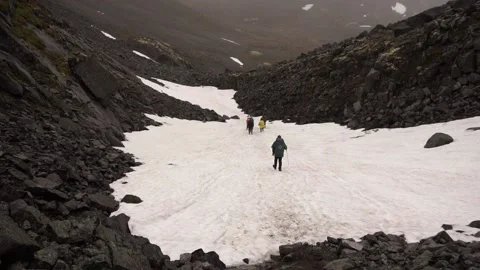A group of tourists with backpacks goes down a mountain. Stock Footage 141365635