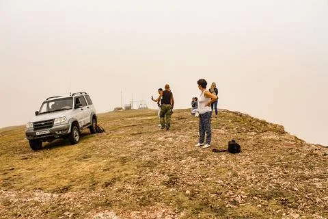 A group of tourists at the edge of the mountain in the cloud. Photos