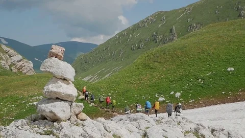 A group of tourists go through a mountain pass Stock Footage 80558392