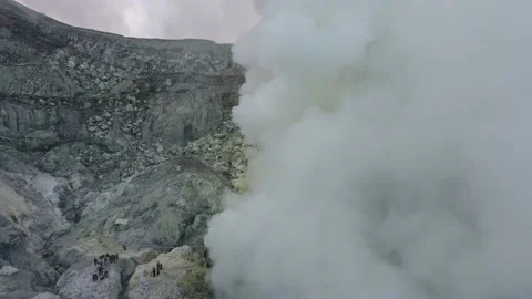 Group of tourists on the mountain is looking at a massive steam cloud, 4k Stock Footage 136804864