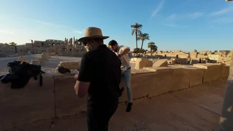 Group of tourists observing ancient hieroglyphic columns inside Karnak Temple Stock Footage 309850059