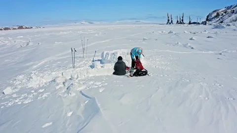 Group of tourists prepares for building igloo on frozen sea Stock Footage 131797921