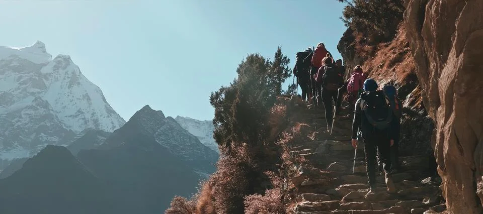 A group of tourists rises on a cliff. Before climbing Mount Everest. Stock Photos