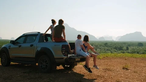 Group of tourists sitting in the back of a pickup truck Stock Footage 128481048