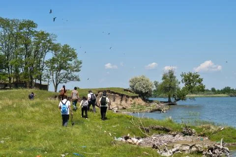 Group of tourists visiting sandy cliffs near the river Stock-Fotos