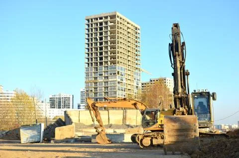 Group tracked excavators at a construction site on a background of a resident Foto stock