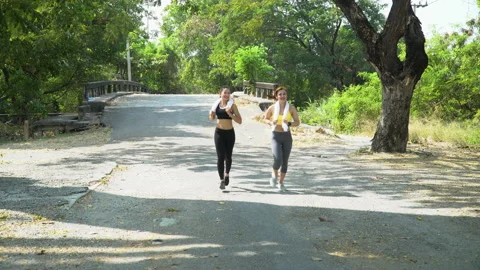 Group of two friend runner asian women wearing sportswear with towel running Stock Footage 158016989