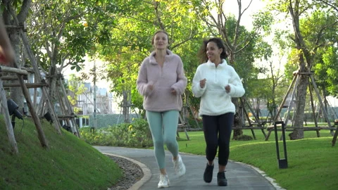 Group of two runner woman wearing sweater giving each other high five meeting Stock Footage 146692525