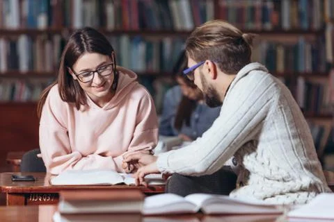 Group of two students studying together at public library Stock Photos