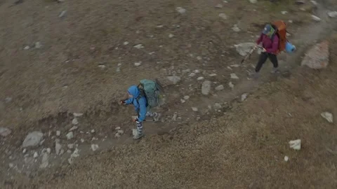 A group of two tourists walks along a mountain trail in the Ala-Archa Stock-Footage 259792069