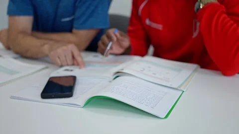 Group of university students collaborating with study materials and smartphone Stock Footage 303597412