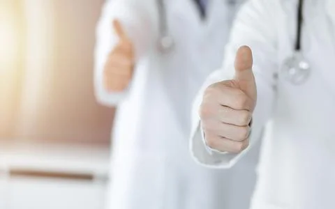 Group of unknown doctors standing as a team with thumbs up or Ok sign in Stock Photos