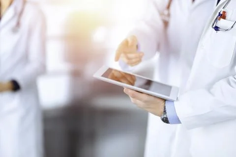 Group of unknown doctors use a computer tablet to check up some medical names Stockfoto's