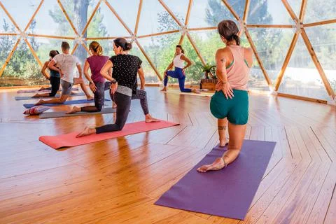 Group of unrecognizable people with instructor practicing yoga in class Stock Photos