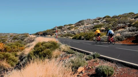 Group of unrecognized athletes cyclists moving up the mountain. Desert landscape Video stock 119776237