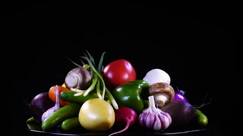 Group of vegetables close up, rotating contra clockwise on black background Stock Footage 77716186