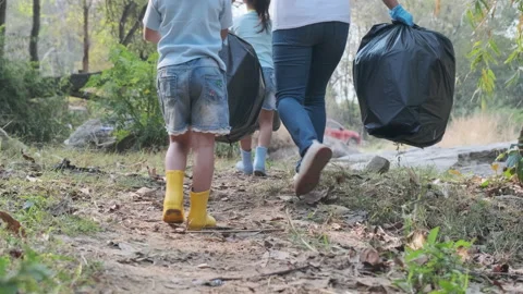 Group of volunteer tying a garbage bag and carry it out after picking up trash. Stock Footage 170877239
