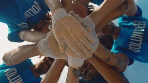 Group volunteers putting their hands together as symbol of unity and teamwork Stock Footage 125121553