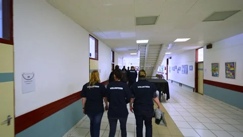 Group of volunteers walking down a corridor Stock Footage 205919199