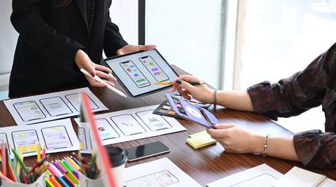 Group of website developer sketching wireframe layout design application for Stock Photos