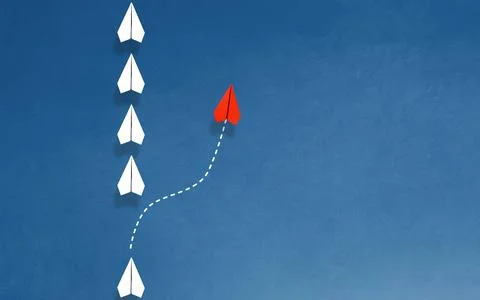 Group of white paper plane in one direction and one red paper plane pointin.. Stock Photos