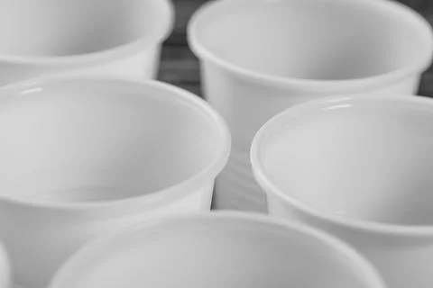 A group of white plastic cups mounted on a black table Stock Photos