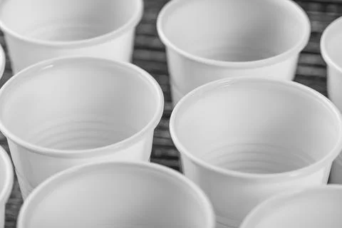 A group of white plastic cups mounted on a black table Foto stock