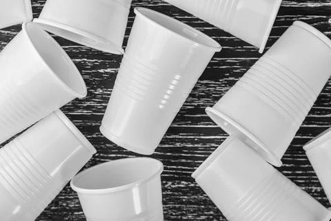 A group of white plastic cups scattered on a black table Foto stock
