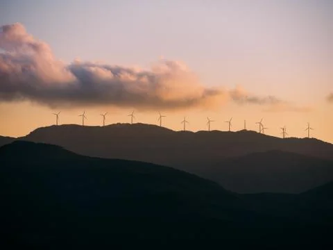 A group of wind generators at the top of a hill Stock Photos