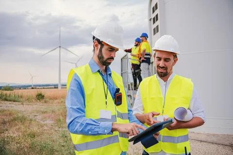 Group of wind mill professional engineers contractors working and using a tablet Stock Photos