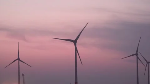 A group of wind power generators generates energy in the evening. Stock Footage 140645365