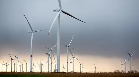 Group of Wind Turbines, Generators in dramatic light, cloudy sky Stock Photos