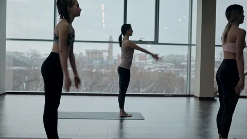 Group of women changing poses during yoga lesson Stock Footage 124289683
