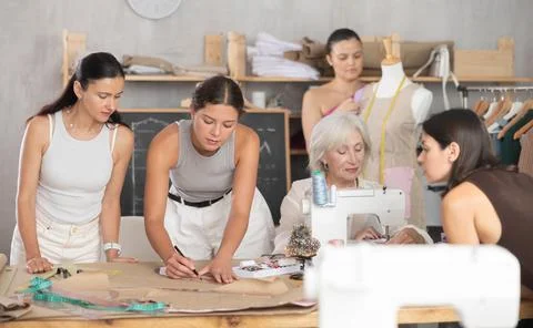 Group of women sew, draw pattern and work with mannequin Stock Photos