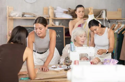Group of women sew, draw pattern and work with mannequin Stock Photos