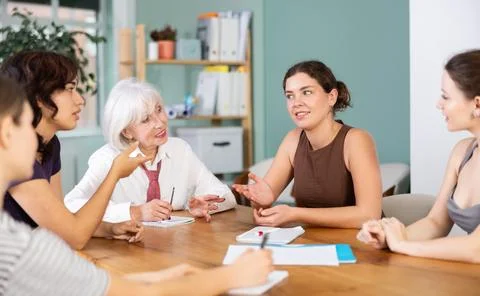 Group of women solving problems sitting around the table Foto stock