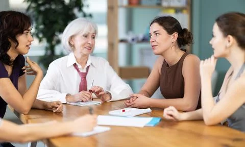 Group of women solving problems sitting around the table Stock-Fotos