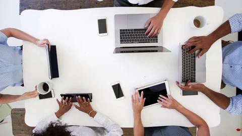 Group work on computers with phones, overhead shot, slo mo Stock Footage 78939168