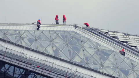 A group of workers are on a building, fixing a window Vídeo Stock 319839009