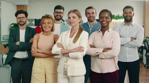 A group of workers are staring directly at the camera while having their arms Stock Footage 166907210